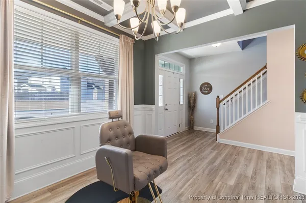 a kitchen with kitchen island granite countertop a refrigerator a stove a sink and white cabinets with wooden floor