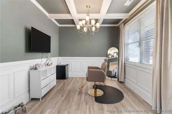 a view of a dining room and livingroom with furniture wooden floor a chandelier