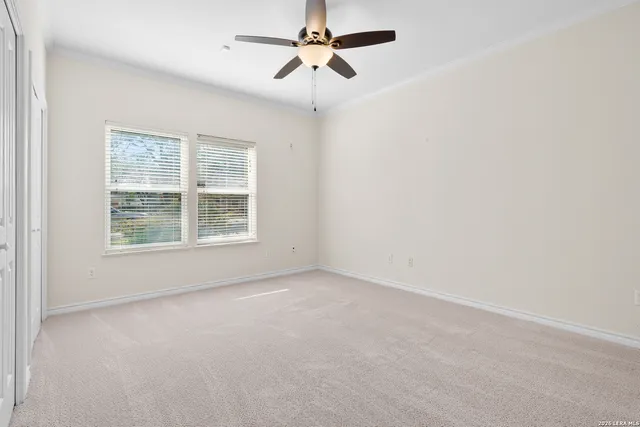 an empty room with windows and fan