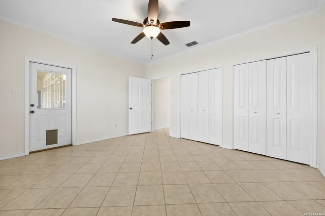 an empty room with fan and windows