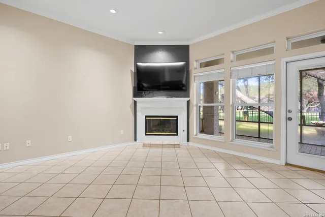 a view of an empty room with a fireplace and a window