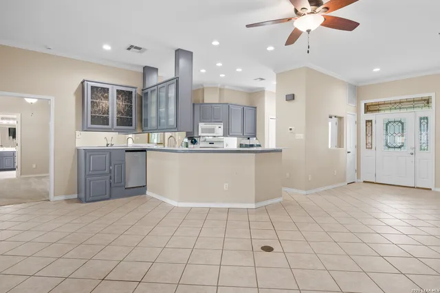 a kitchen with stainless steel appliances a sink a stove a refrigerator cabinets and a window