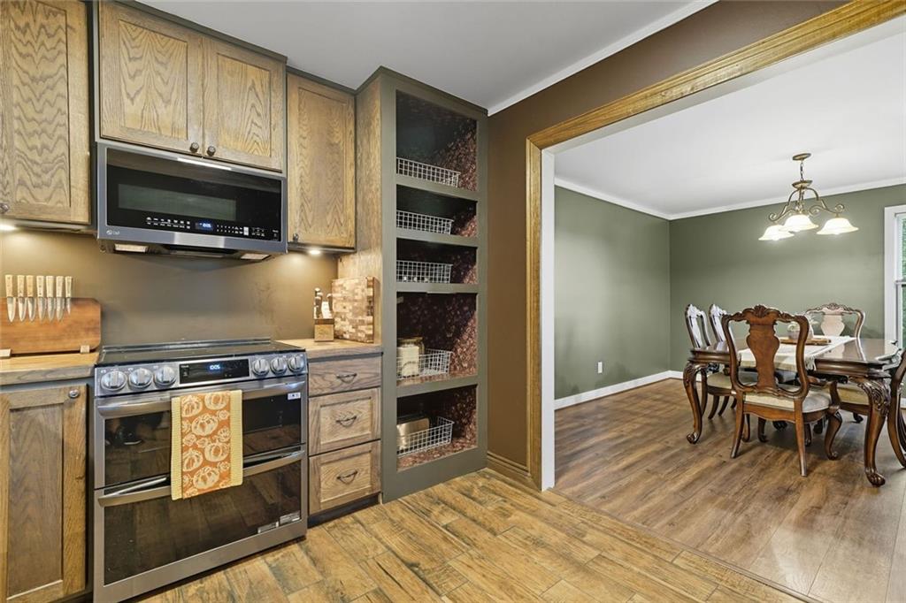 275 Old Whitestone Road West Talking Rock, GA 30175 - Photo 11 of 30 a kitchen with stainless steel appliances a stove a sink cabinets and a dining table