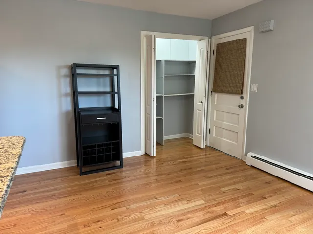 a view of empty room with wooden floor and closet