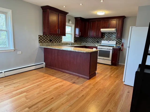 a kitchen with stainless steel appliances granite countertop a stove a sink and a refrigerator