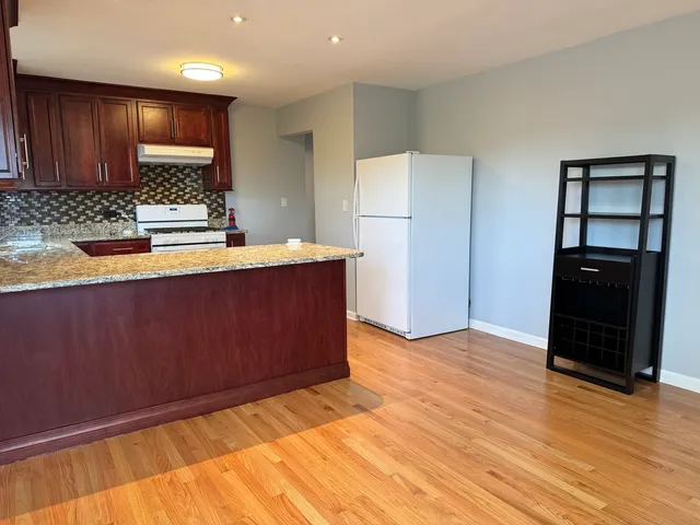 a kitchen with granite countertop wooden cabinets and a granite counter top