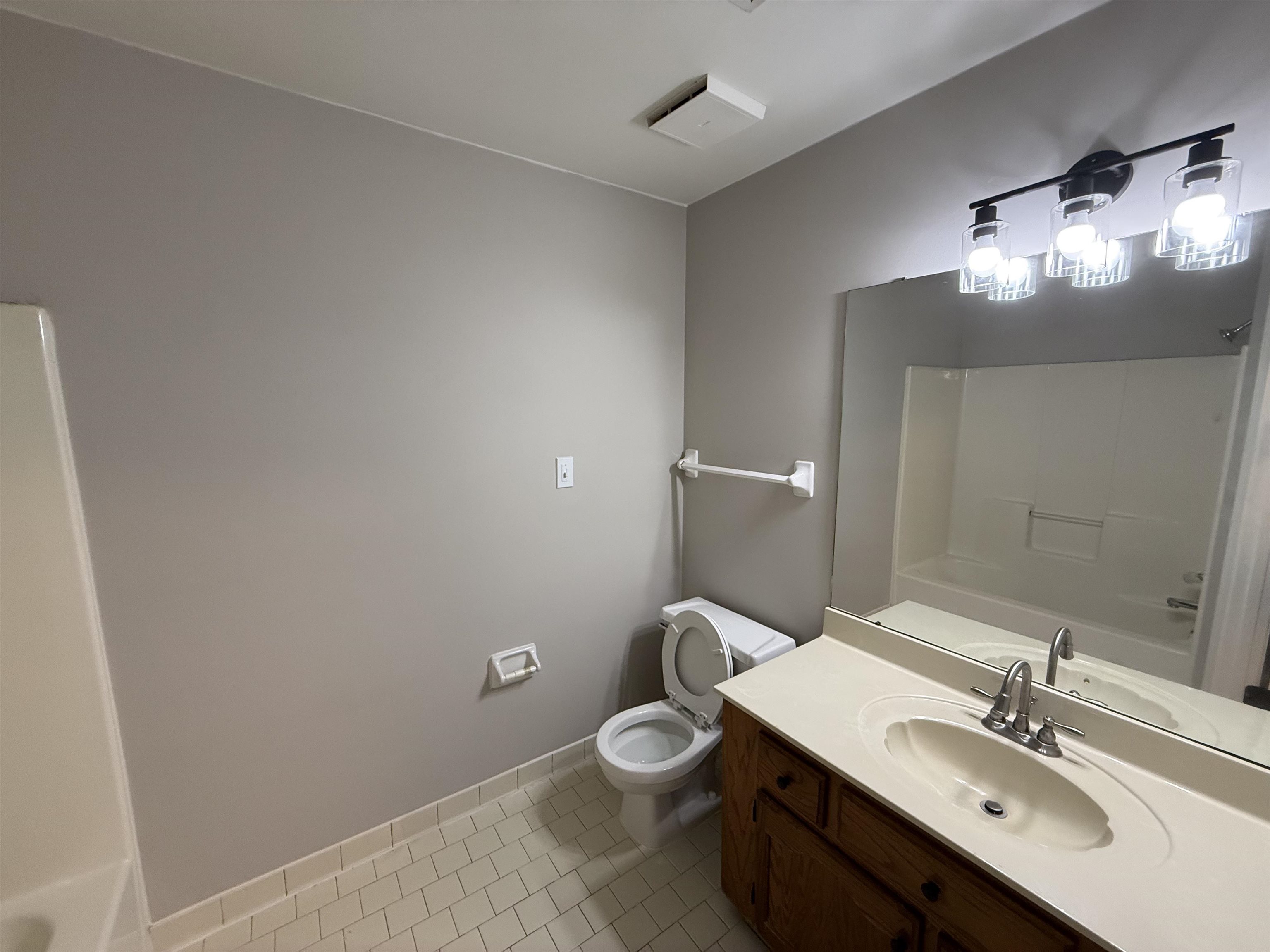 6913 Snyder Road Memphis, TN 38141 - Photo 9 of 20 Bathroom featuring a single vanity with a laminate countertop, integrated sink, and wood-finish cabinetry