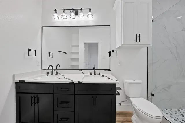 a bathroom with a sink vanity mirror and toilet