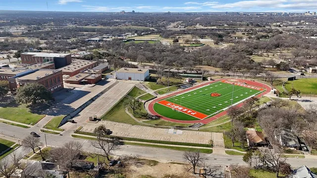 an aerial view of a pool yard and mountain view in back