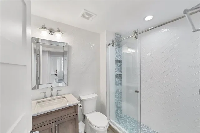 a bathroom with a sink vanity mirror and toilet