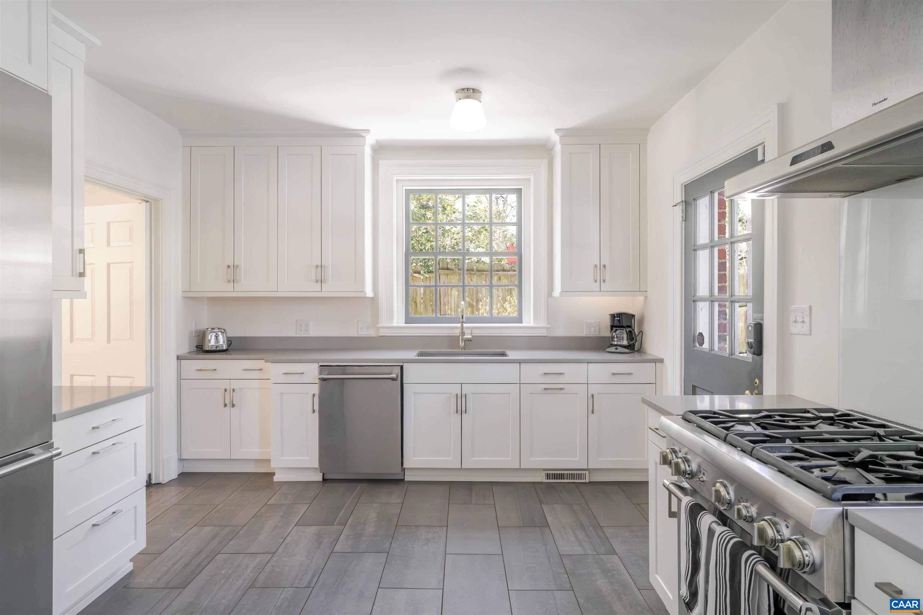 921 Rugby Road Charlottesville, VA 22903 - Photo 21 of 41 a kitchen with a sink stove and cabinets