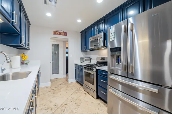a bed sitting in a bedroom next to a window and a chandelier