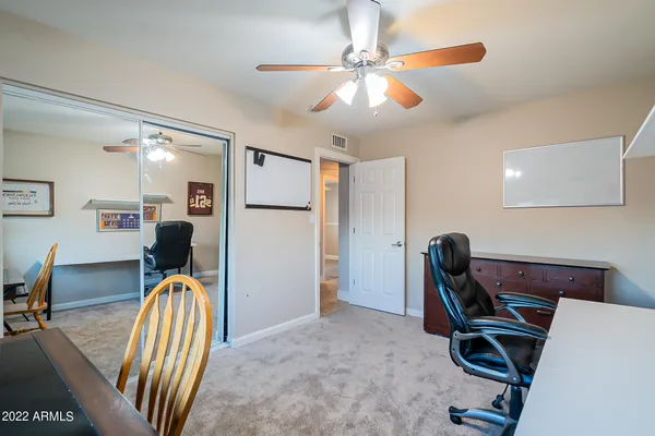 a spacious bedroom with a bed and a ceiling fan