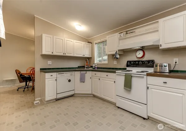a kitchen with granite countertop cabinets and white appliances