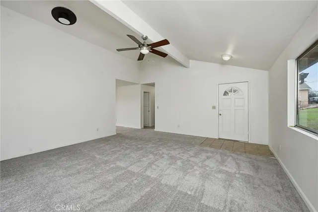 an empty room with windows and ceiling fan view