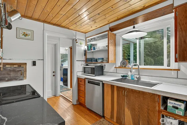 a kitchen with stainless steel appliances granite countertop a sink and a refrigerator