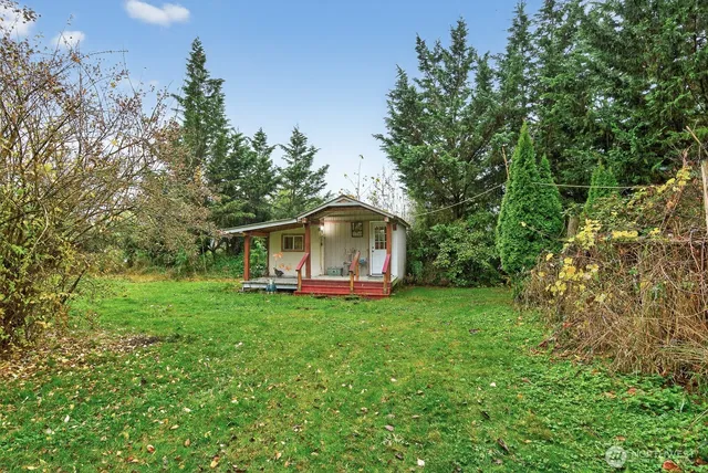 a white house with a small yard and large trees