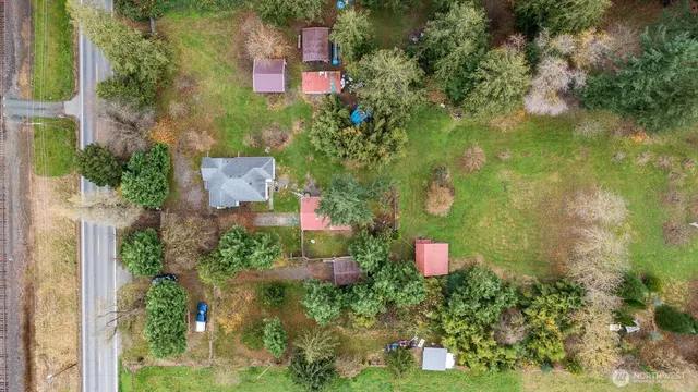 an aerial view of a house with a yard and large trees