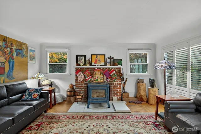 a living room with furniture a rug a fireplace and a window