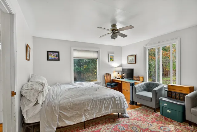 a spacious bedroom with a bed a couch and large window