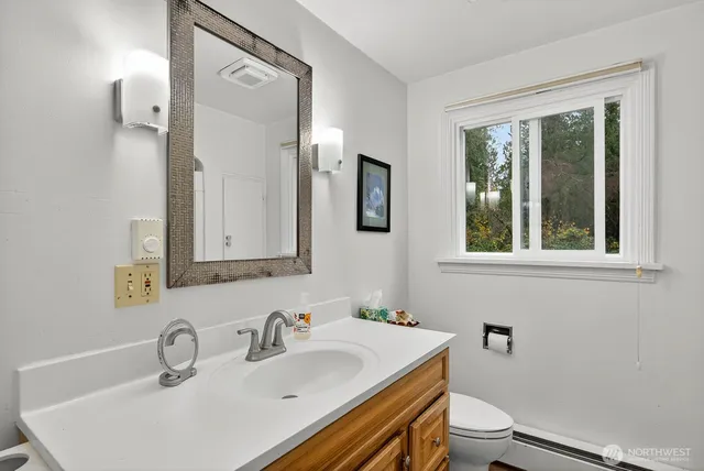 a bathroom with a sink toilet and mirror