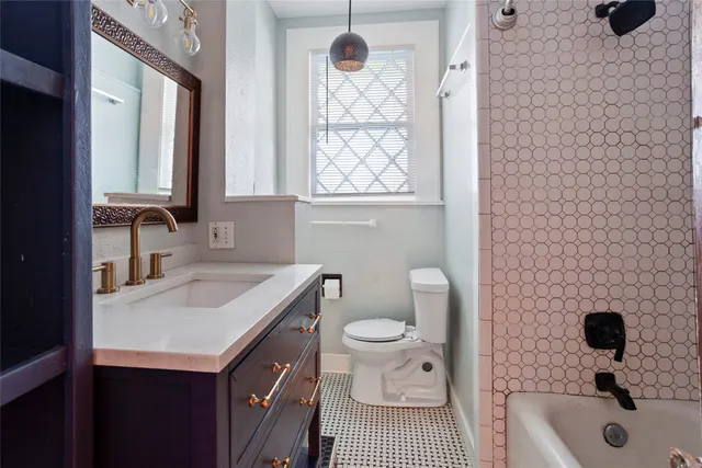 a bathroom with a sink a toilet a window and vanity