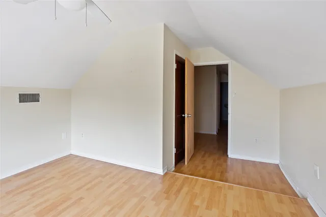 an empty room with wooden floor and entrance