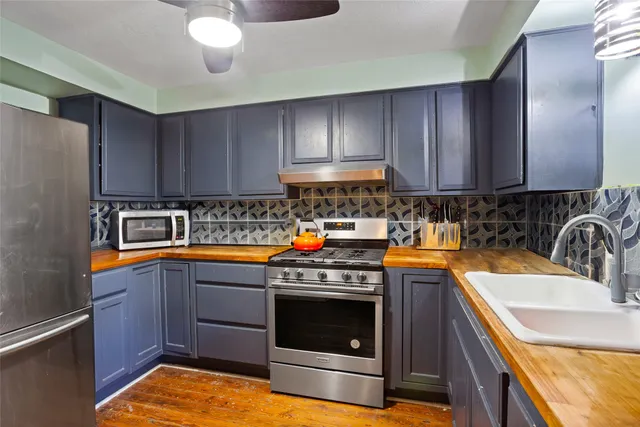 a kitchen with stainless steel appliances granite countertop a sink stove and refrigerator