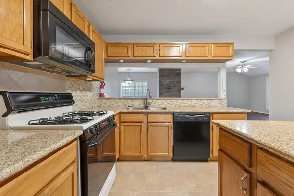 a kitchen with stainless steel appliances granite countertop a stove sink and cabinets