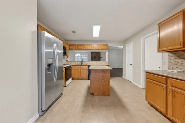 a large kitchen with cabinets stainless steel appliances a sink and a large window