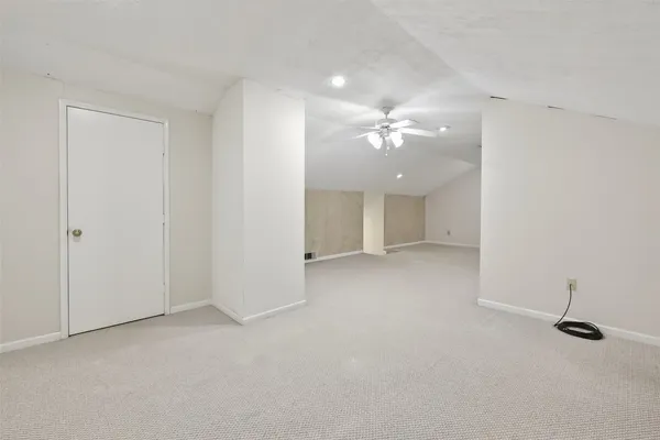 an empty room with a ceiling fan and a window