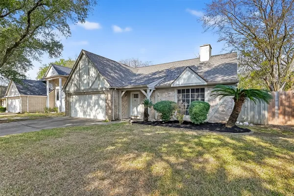 a front view of a house with a yard and potted plants