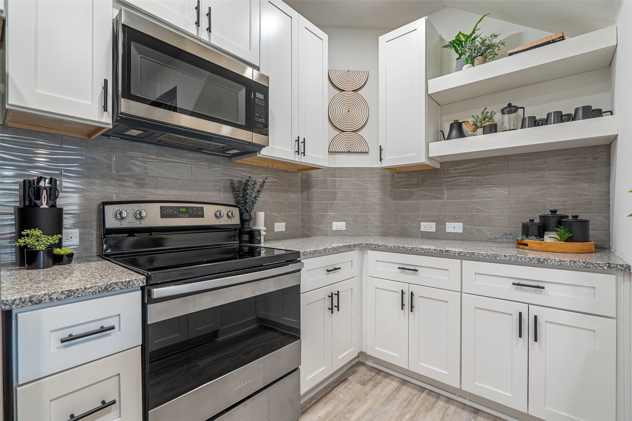 21202 Boggy Ford Road, Unit 6 Lago Vista, TX 78645 - Photo 5 of 36 a kitchen with granite countertop cabinets stainless steel appliances and wooden floor