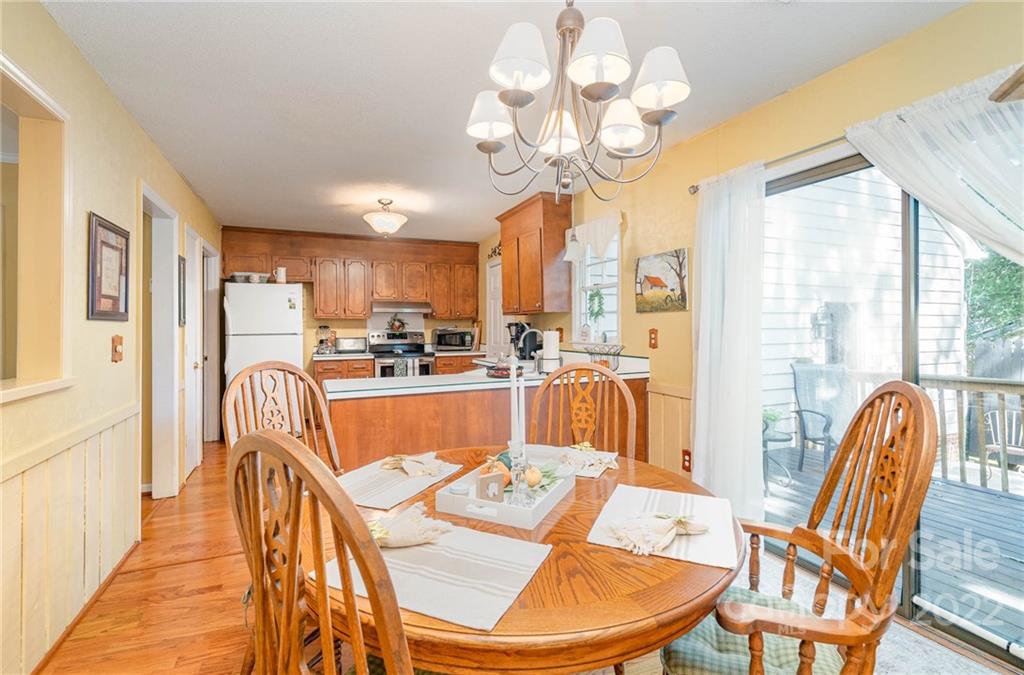 6901 Porterfield Road Charlotte, NC 28226 - Photo 15 of 30 a dining room filled chandelier and wooden floor