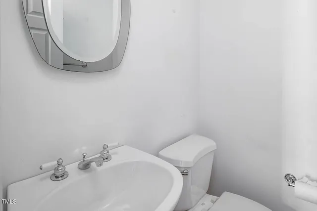 a bathroom with a sink mirror and toilet