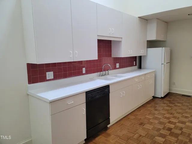 a kitchen with a sink cabinets and a refrigerator
