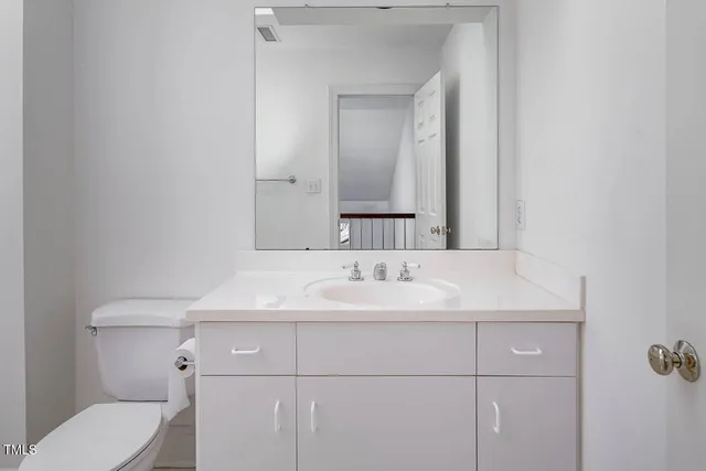 a bathroom with a sink toilet and mirror