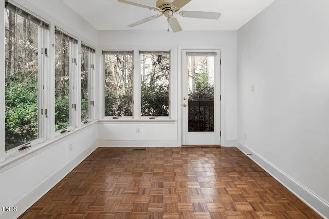 a view of a room with large windows and plants