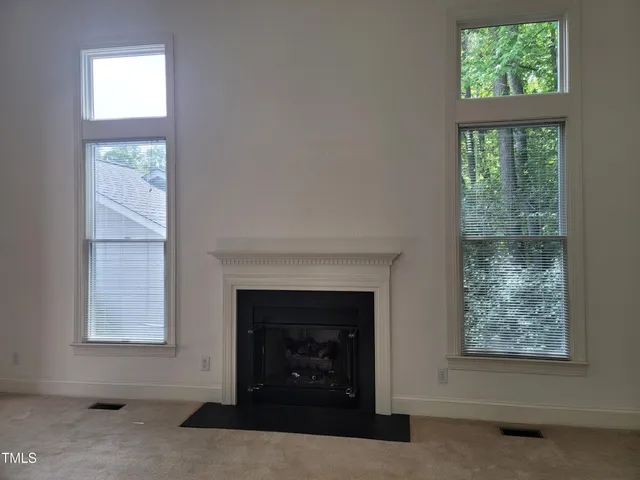 a view of an empty room with stairs and a window