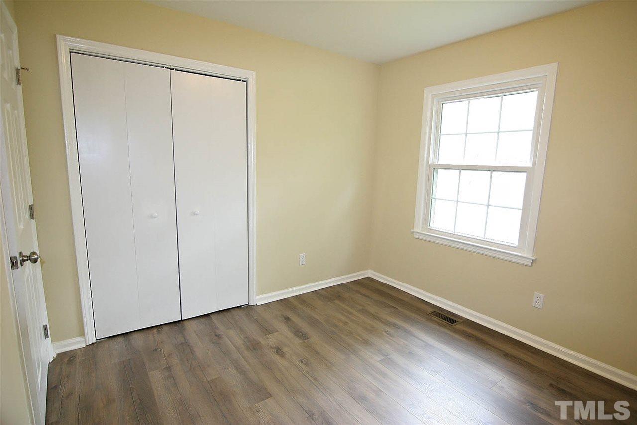 7033 Buck Road Wendell, NC 27591 - Photo 13 of 25 an empty room with wooden floor and windows