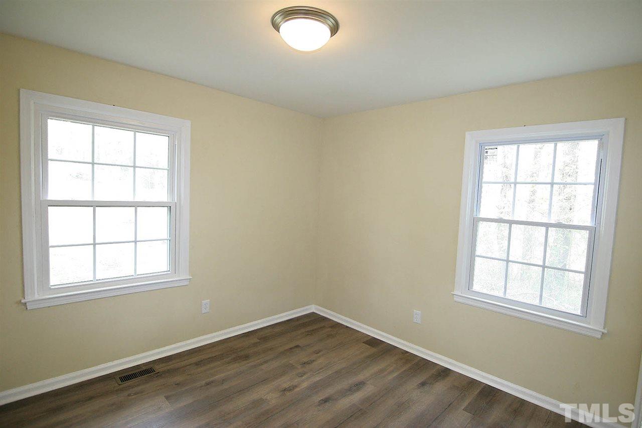 7033 Buck Road Wendell, NC 27591 - Photo 14 of 25 an empty room with wooden floor and windows