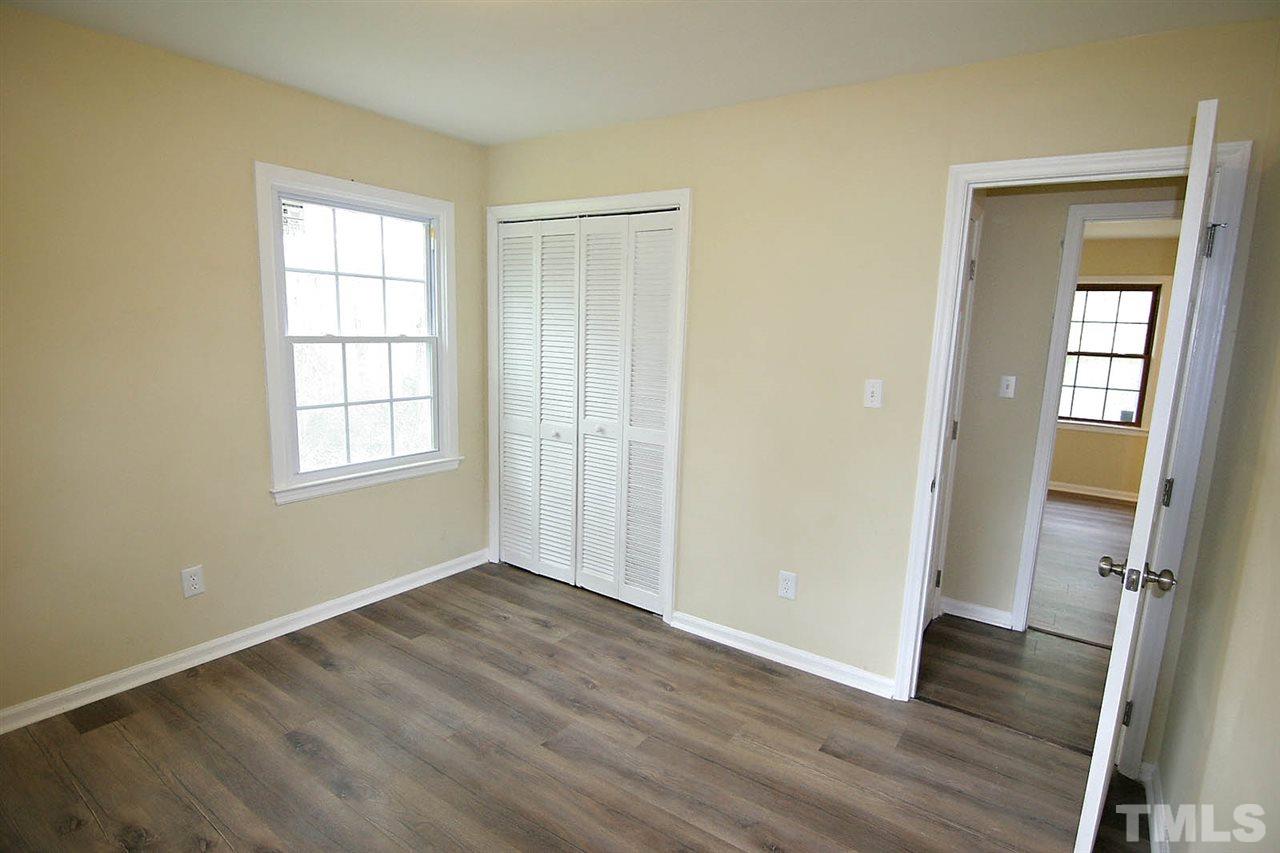 7033 Buck Road Wendell, NC 27591 - Photo 15 of 25 an empty room with wooden floor and windows
