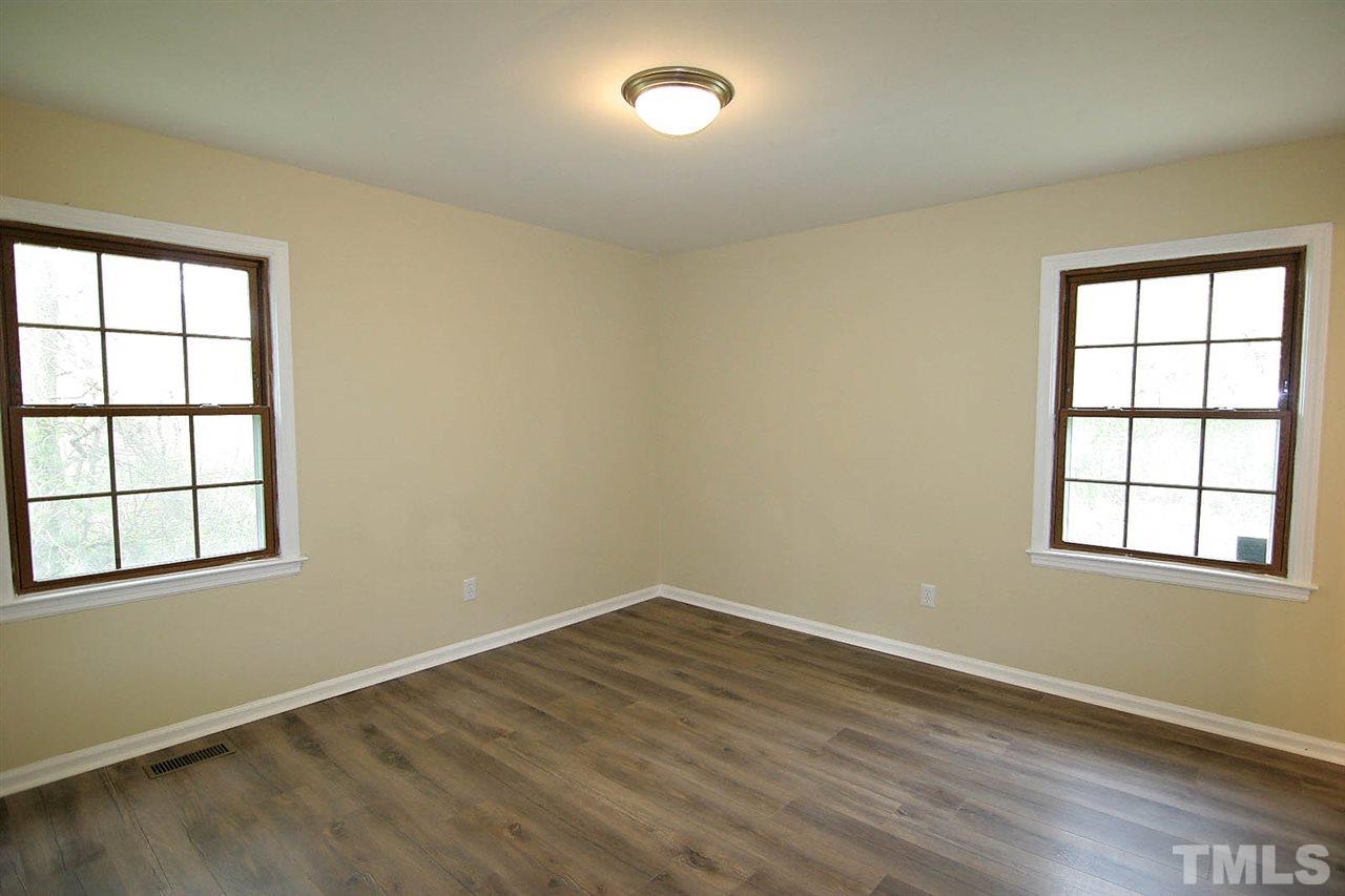 7033 Buck Road Wendell, NC 27591 - Photo 16 of 25 an empty room with wooden floor and windows