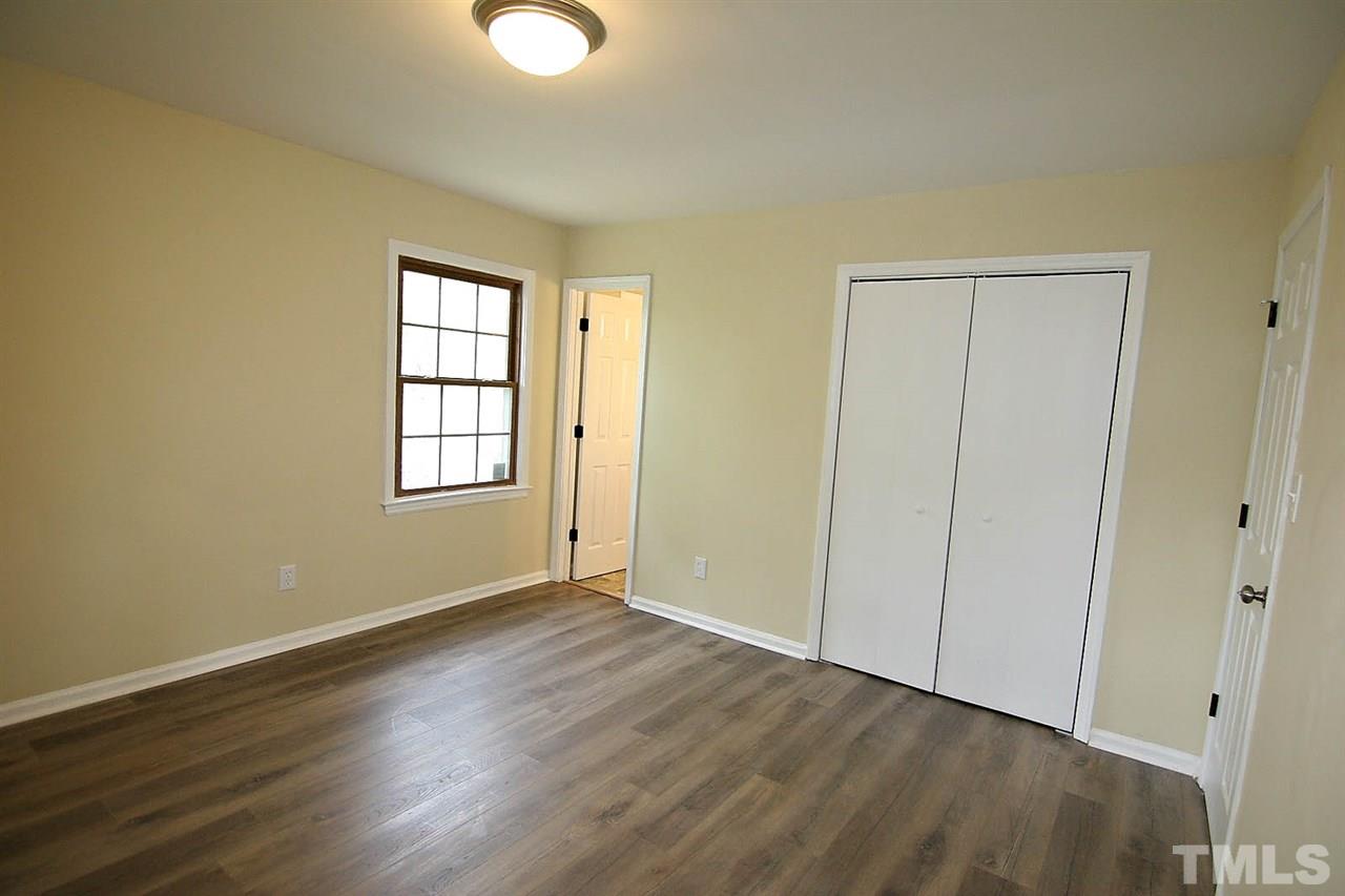 7033 Buck Road Wendell, NC 27591 - Photo 17 of 25 a view of an empty room with wooden floor and a window