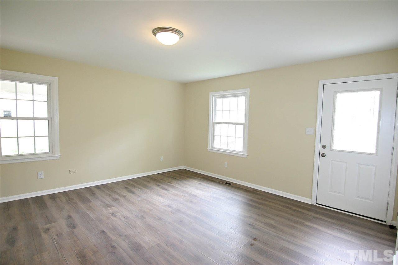 7033 Buck Road Wendell, NC 27591 - Photo 3 of 25 an empty room with wooden floor and windows