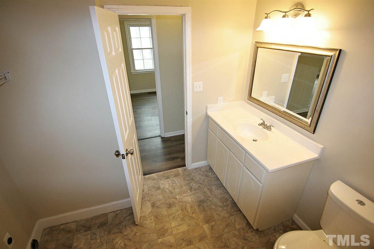 7033 Buck Road Wendell, NC 27591 - Photo 21 of 25 a bathroom with a sink a toilet and mirror