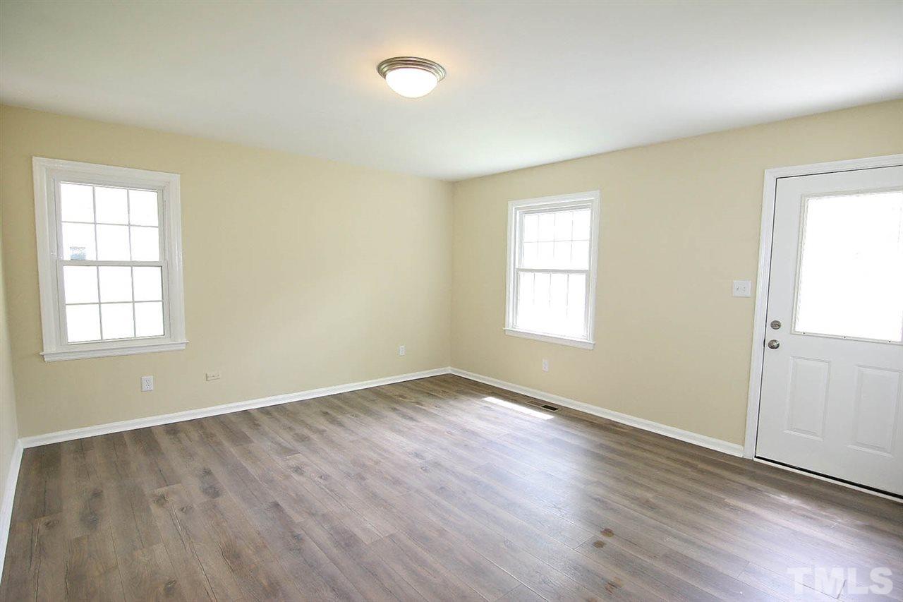 7033 Buck Road Wendell, NC 27591 - Photo 4 of 25 an empty room with wooden floor and windows