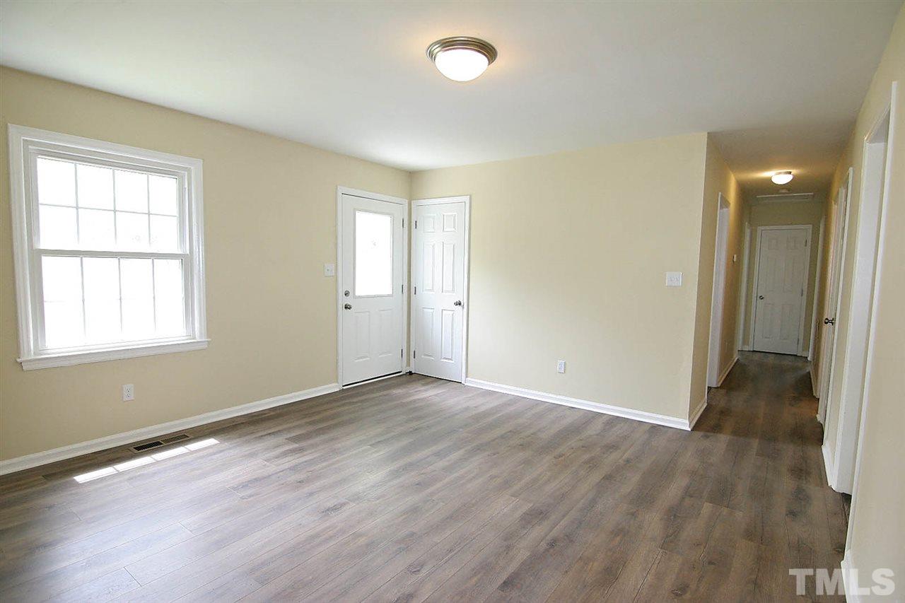 7033 Buck Road Wendell, NC 27591 - Photo 5 of 25 an empty room with wooden floor and windows