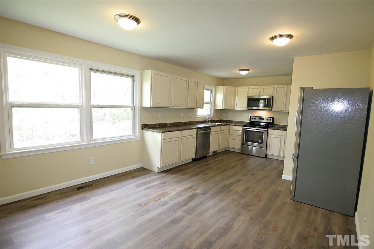 7033 Buck Road Wendell, NC 27591 - Photo 7 of 25 a kitchen with stainless steel appliances granite countertop a stove top oven a sink dishwasher and a refrigerator
