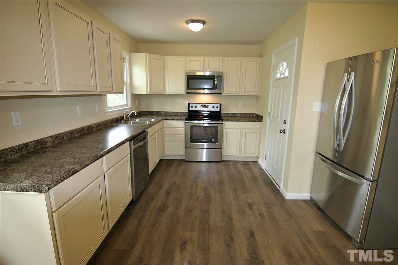 7033 Buck Road Wendell, NC 27591 - Photo 9 of 25 a kitchen with granite countertop wooden floors stainless steel appliances and a sink